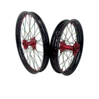 Black and red Sur Ron aluminum wheel set with rainbow spokes