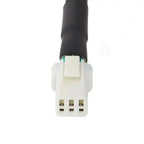 White plastic Sur-Ron Ultra Bee taillight connector with black cable and green stripe